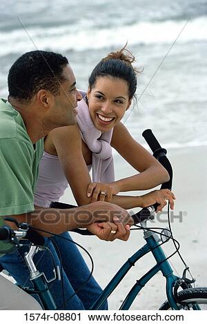 Stock Image - Young couple on bicycles at the beach. Fotosearch