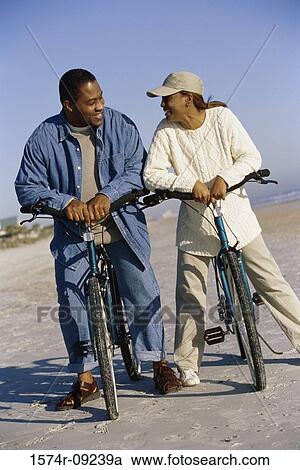 Stock Image - Young couple on bicycles at the beach. Fotosearch