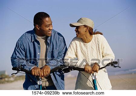 Young couple on bicycles at the beach View Large Photo Image Stock Image - Young couple on bicycles at the beach. Fotosearch