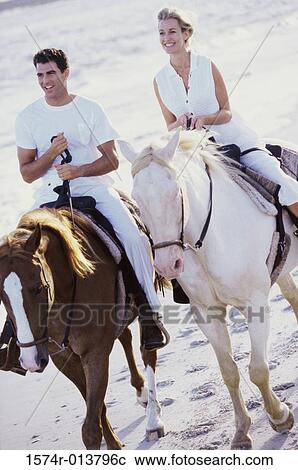 Young couple riding horses on the beach View Large Photo Image Stock Image - Young couple riding horses on the beach. Fotosearch
