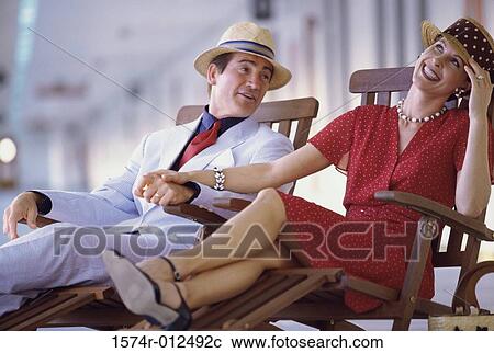 Young couple sitting in deck chairs on a cruise ship View Large Photo Image Stock Image - Young couple sitting in deck chairs on a cruise ship. Fotosearch