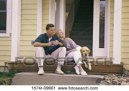 Young couple sitting on the front porch with their dog View Large Photo Image Stock Image - Young couple sitting on the front porch with their dog. Fotosearch
