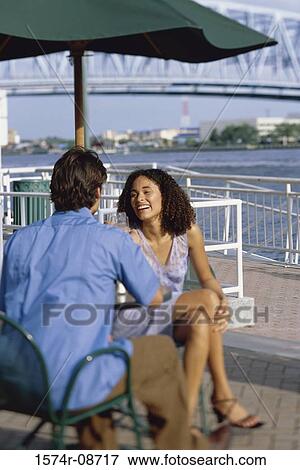 Stock Photo - Young couple sitting together outdoors. Fotosearch