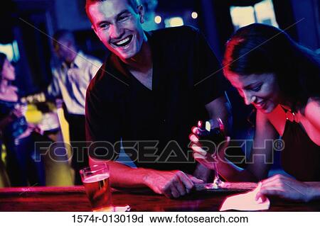 Young couple standing at a bar counter View Large Photo Image Stock Image - Young couple standing at a bar counter. Fotosearch