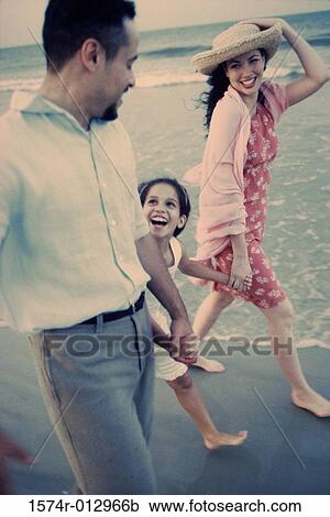 Young couple walking on the beach with their daughter View Large Photo Image Stock Image - Young couple walking on the beach with their daughter. Fotosearch