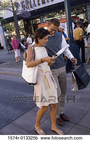 Young couple walking on the sidewalk View Large Photo Image Stock Image - Young couple walking on the sidewalk. Fotosearch