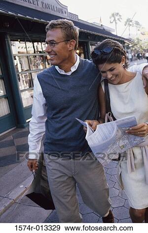 Young couple walking on the sidewalk View Large Photo Image Stock Photo - Young couple walking on the sidewalk. Fotosearch