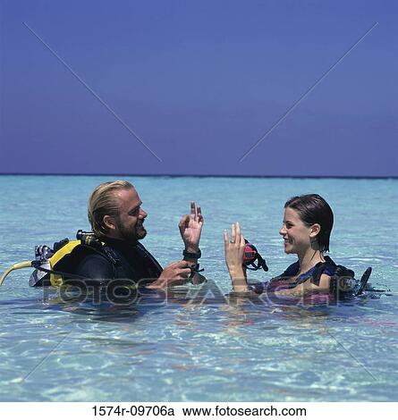 Young man and a young woman with scuba gear in the sea View Large Photo Image Stock Image - Young man and a young woman with scuba gear in the sea. Fotosearch