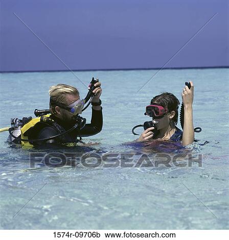 Young man and a young woman with scuba gear in the sea View Large Photo Image Stock Image - Young man and a young woman with scuba gear in the sea. Fotosearch