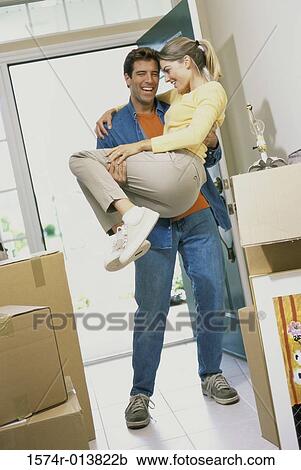 Young man carrying a young woman into their new house View Large Photo Image Stock Image - Young man carrying a young woman into their new house. Fotosearch
