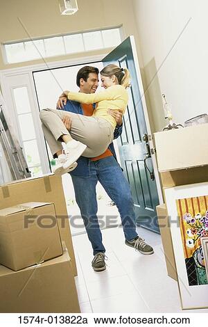 Stock Image - Young man carrying a young woman. Fotosearch