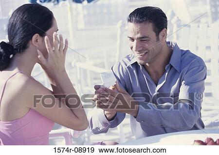 Young man giving a young woman an engagement ring View Large Photo Image Stock Photo - Young man giving a young woman an engagement ring. Fotosearch