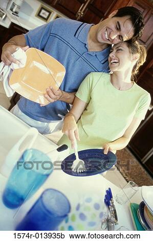 Young man helping a young woman in a kitchen View Large Photo Image Stock Image - Young man helping a young woman in a kitchen. Fotosearch