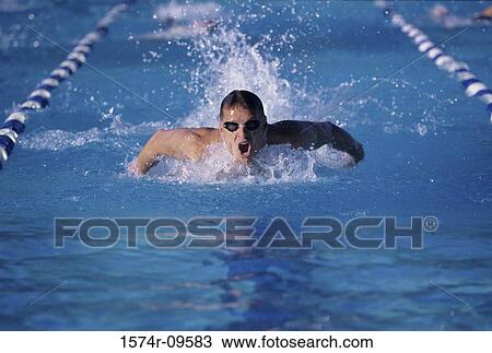 Young man swimming in a swimming pool View Large Photo Image Stock Image - Young man swimming in a swimming pool. Fotosearch