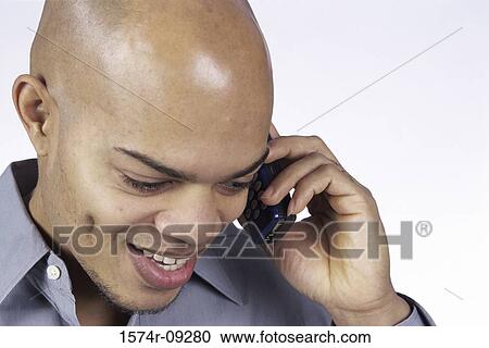 Young man talking on a mobile phone View Large Photo Image Stock Image - Young man talking on a mobile phone. Fotosearch