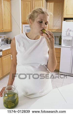Young pregnant woman eating pickles View Large Photo Image Stock Photo - Young pregnant woman eating pickles. Fotosearch