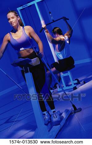 Young woman and a young man exercising in a gym View Large Photo Image Stock Image - Young woman and a young man exercising in a gym. Fotosearch