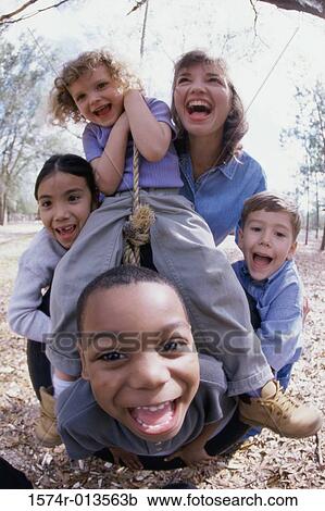 Young woman and four children playing on a tire swing View Large Photo Image Stock Image - Young woman and four children playing on a tire swing. Fotosearch