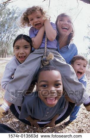 Young woman and four children playing on a tire swing View Large Photo Image Stock Image - Young woman and four children playing on a tire swing. Fotosearch