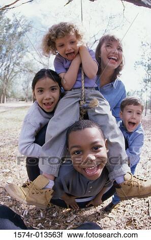 Young woman and four children playing on a tire swing View Large Photo Image Stock Image - Young woman and four children playing on a tire swing. Fotosearch