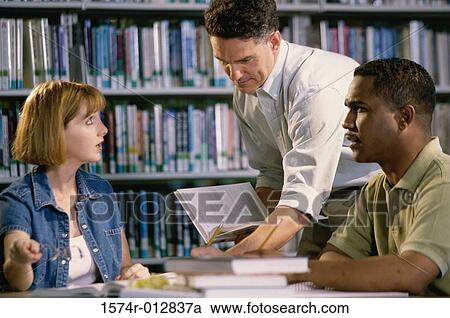 Young woman and two mid adult men studying in a library View Large Photo Image Stock Image - Young woman and two mid adult men studying in a library. Fotosearch