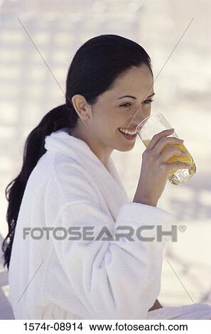 Young woman drinking a glass of orange juice View Large Photo Image Picture - Young woman drinking a glass of orange juice. Fotosearch