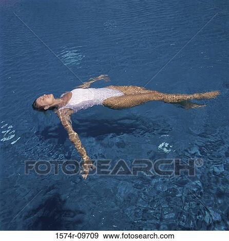 Young woman floating on water View Large Photo Image Stock Photo - Young woman floating on water. Fotosearch