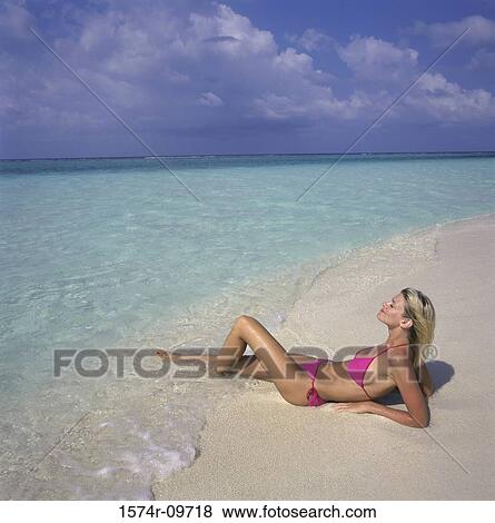 Young woman lying on the beach View Large Photo Image Stock Photo - Young woman lying on the beach. Fotosearch