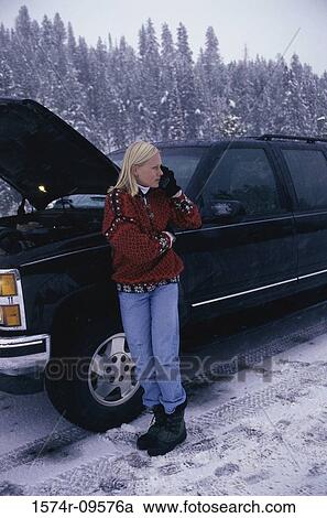 Young woman near a broken down car talking on a mobile phone View Large Photo Image Stock Image - Young woman near a broken down car talking on a mobile phone. Fotosearch