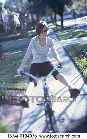 Young woman riding a bicycle View Large Photo Image Stock Image - Young woman riding a bicycle. Fotosearch