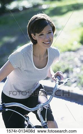 Young woman riding a bicycle View Large Photo Image Stock Image - Young woman riding a bicycle. Fotosearch