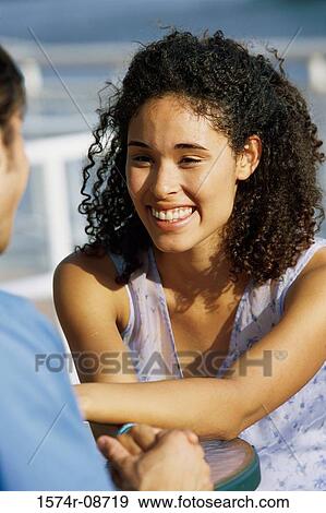 Young woman sitting with a young man View Large Photo Image Stock Photo - Young woman sitting with a young man. Fotosearch