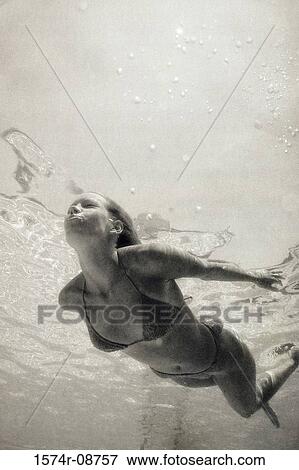 Young woman swimming in a swimming pool View Large Photo Image Stock Photo - Young woman swimming in a swimming pool. Fotosearch
