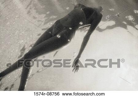 Young woman swimming in a swimming pool View Large Photo Image Stock Photograph - Young woman swimming in a swimming pool. Fotosearch