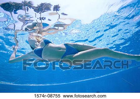 Young woman swimming in a swimming pool View Large Photo Image Stock Photography - Young woman swimming in a swimming pool. Fotosearch