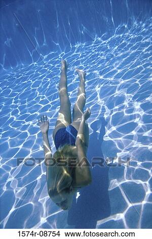Picture - Young woman swimming underwater in a swimming pool. Fotosearch