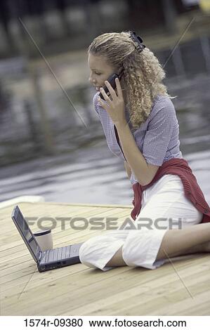 Young woman talking on a mobile phone View Large Photo Image Stock Image - Young woman talking on a mobile phone. Fotosearch