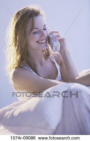 Young woman talking on a telephone View Large Photo Image Stock Photograph - Young woman talking on a telephone. Fotosearch