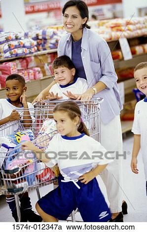 Stock Image - Young woman with four children in a supermarket. Fotosearch