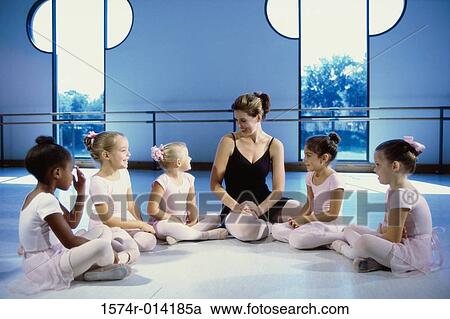 Stock Image - Ballet teacher talking to a group of girls. Fotosearch
