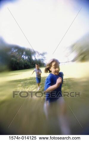Boy chasing a girl on a lawn View Large Photo Image Stock Photography - Boy chasing a girl on a lawn. Fotosearch