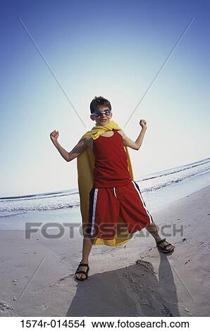 Boy flexing his muscles on the beach View Large Photo Image Picture - Boy flexing his muscles on the beach. Fotosearch