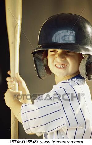 Stock Photo - Boy in a baseball uniform holding a baseball bat. Fotosearch