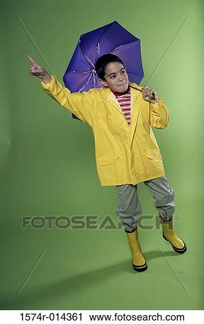 Boy wearing a raincoat and holding an umbrella View Large Photo Image Stock Image - Boy wearing a raincoat and holding an umbrella. Fotosearch