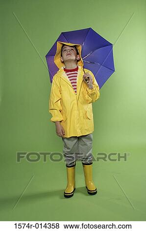 Boy wearing a raincoat and holding an umbrella View Large Photo Image Stock Photo - Boy wearing a raincoat and holding an umbrella. Fotosearch