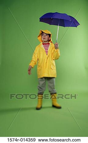Boy wearing a raincoat and holding an umbrella View Large Photo Image Stock Photo - Boy wearing a raincoat and holding an umbrella. Fotosearch