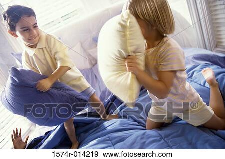 Brother and sister having a pillow fight on the bed View Large Photo Image Stock Photo - Brother and sister having a pillow fight on the bed. Fotosearch