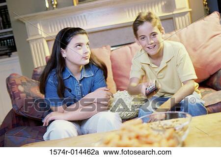 Brother watching television with his sister sitting beside him View Large Photo Image Stock Image - Brother watching television with his sister sitting beside him. Fotosearch