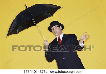 Businessman holding an umbrella View Large Photo Image Stock Image - Businessman holding an umbrella. Fotosearch