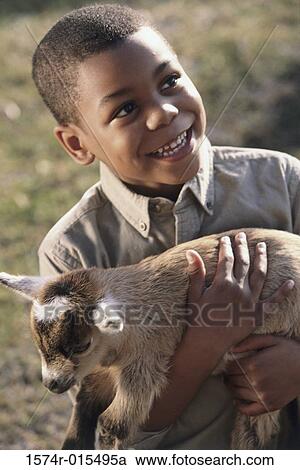Close-up of a boy holding a lamb View Large Photo Image Stock Image - Close-up of a boy holding a lamb. Fotosearch